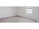Empty bedroom featuring neutral carpet, white walls, baseboards and trim, and a window at 545 Jerry Ln, Haines City, FL 33844