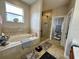 Bright bathroom features a soaking tub, separate glass shower and neutral tile at 546 Nogales Ct, Kissimmee, FL 34758