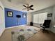 Bedroom features a blue accent wall, a large window, and a ceiling fan with a light at 546 Nogales Ct, Kissimmee, FL 34758