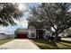 Charming two-story home with a well-manicured lawn, mature landscaping, and a red two-car garage door at 546 Nogales Ct, Kissimmee, FL 34758