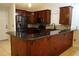 This kitchen features dark wood cabinets, stainless steel appliances and a countertop bar at 6501 Abercrombie Ct, Orlando, FL 32835