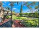 Screened-in patio view showcasing a well-maintained lawn, trimmed hedges, and colorful mulch landscaping in the backyard at 7217 Dr Phillips Blvd, Orlando, FL 32819