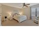 Cozy bedroom features neutral walls, ceiling fan, and a comfy bed with a white headboard at 7217 Dr Phillips Blvd, Orlando, FL 32819