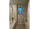 Bathroom features a shower-tub, tiled walls and flooring and a window for natural light at 7606 Loon Ave, Winter Garden, FL 34787