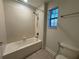 Bathroom with shower-tub, tile flooring, and a window for natural light at 7606 Loon Ave, Winter Garden, FL 34787