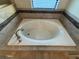 Bathroom featuring a soaking tub with tiled surround and natural light at 7606 Loon Ave, Winter Garden, FL 34787