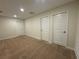 Bedroom with neutral walls and carpet, illuminated by recessed lights and featuring two closets and a vent at 7606 Loon Ave, Winter Garden, FL 34787