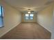 Carpeted bedroom featuring a ceiling fan and natural light from two windows at 7606 Loon Ave, Winter Garden, FL 34787