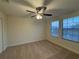 Cozy bedroom with a ceiling fan, carpet, and two bright windows with blinds at 7606 Loon Ave, Winter Garden, FL 34787