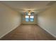 Carpeted bedroom featuring a ceiling fan and natural light from two windows at 7606 Loon Ave, Winter Garden, FL 34787