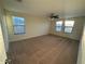 Bedroom with tan carpeting, ceiling fan, and natural light coming in through the two windows at 7606 Loon Ave, Winter Garden, FL 34787