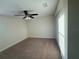 Neutral carpeted bedroom features a ceiling fan and closet at 7606 Loon Ave, Winter Garden, FL 34787