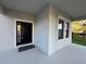 Welcoming front porch with a black front door framed by white trim and sidelight windows at 7606 Loon Ave, Winter Garden, FL 34787