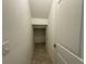 Hallway leading to a storage area, featuring tiled floors and a white door at 7606 Loon Ave, Winter Garden, FL 34787