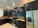 Modern kitchen featuring dark cabinets, stainless steel appliances, and granite countertops at 7606 Loon Ave, Winter Garden, FL 34787