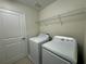 Convenient laundry room featuring a white washer, dryer, and wire shelving for storage at 7606 Loon Ave, Winter Garden, FL 34787