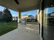 Covered patio with a stone-clad built-in grill, perfect for outdoor cooking and entertaining at 7606 Loon Ave, Winter Garden, FL 34787