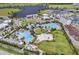 Aerial view of community pools, playground and landscaping by the lake at 8266 Tavistock Lakes Blvd, Orlando, FL 32827