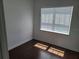 Bedroom with hardwood floors, white walls, and light streaming through window at 8266 Tavistock Lakes Blvd, Orlando, FL 32827