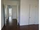 Hallway showcases hardwood floors and white doors creating an airy feel at 8266 Tavistock Lakes Blvd, Orlando, FL 32827