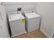 Bright laundry room featuring white washer and dryer with overhead shelving at 8266 Tavistock Lakes Blvd, Orlando, FL 32827