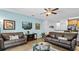 Comfortable living room featuring leather sofas, a ceiling fan, and access to the kitchen at 9114 Stromboli Ct, Kissimmee, FL 34747