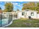 Backyard featuring a pool with a black safety fence and a white home with green trim at 10526 Fernando St, Orlando, FL 32825