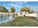 Backyard featuring a pool with safety fence, white house with green trim, and sparse grass at 10526 Fernando St, Orlando, FL 32825