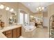 Luxurious bathroom with a jacuzzi tub, double vanity sinks, and tile flooring at 10742 Boca Pointe Dr, Orlando, FL 32836