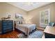 Comfortable bedroom with hardwood floors, a blue accent dresser, and plenty of natural light at 10742 Boca Pointe Dr, Orlando, FL 32836