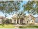 Elegant home with mature landscaping, a palm tree, and a stately columned entrance at 10742 Boca Pointe Dr, Orlando, FL 32836