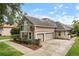 A two-story home featuring a stone accent, balcony, well-kept lawn, and a three-car garage at 10742 Boca Pointe Dr, Orlando, FL 32836