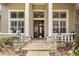 Elegant front porch featuring stone accents, stately columns, and a stylish front door with transom window at 10742 Boca Pointe Dr, Orlando, FL 32836
