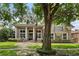 Stunning two-story home featuring stately columns, a welcoming front porch, lush landscaping, and an elegant balcony at 10742 Boca Pointe Dr, Orlando, FL 32836
