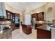 A well-lit kitchen with dark wood cabinets, stainless steel appliances, and a granite island at 10742 Boca Pointe Dr, Orlando, FL 32836