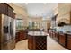 Open kitchen with a large island, stainless steel refrigerator, and dark wood cabinets at 10742 Boca Pointe Dr, Orlando, FL 32836