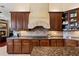 A gourmet kitchen boasts dark wood cabinetry, stone accents, and granite countertops at 10742 Boca Pointe Dr, Orlando, FL 32836