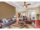 Expansive living room featuring wood floors, tray ceiling, and seamless flow to kitchen and dining area at 10742 Boca Pointe Dr, Orlando, FL 32836