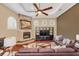 Cozy Gathering room with a stone fireplace, tray ceiling, and built-in shelving for entertainment at 10742 Boca Pointe Dr, Orlando, FL 32836