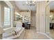 Bright bathroom with a soaking tub, tiled floors, dual sinks, and vanity at 10742 Boca Pointe Dr, Orlando, FL 32836