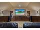 Home theater with a large screen, comfortable seating, and sconce lighting at 10742 Boca Pointe Dr, Orlando, FL 32836