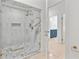 A modern bathroom featuring marble tiling in glass shower and entry to secondary bathroom at 1109 Brownshire Ct, Longwood, FL 32779