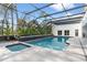 Enclosed pool area featuring a spa, lush greenery, and tiled patio at 1109 Brownshire Ct, Longwood, FL 32779