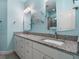 Bathroom featuring double sinks with granite counters, decorative mirrors and a tub shower at 1132 Fins Up Ct, Daytona Beach, FL 32124