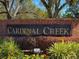 Elegant community sign for Cardinal Creek set against a brick wall and colorful landscaping at 1165 Cardinal Creek Pl, Oviedo, FL 32765