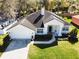 Aerial view of a charming single-story home with well-manicured lawn, white exterior, and attached two-car garage at 1165 Cardinal Creek Pl, Oviedo, FL 32765