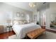 Bright main bedroom featuring a large bed, hardwood floors, and plantation shutters at 1165 Cardinal Creek Pl, Oviedo, FL 32765