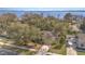 Aerial view of a residential home with mature trees and a well-manicured lawn near a glistening lake at 1224 Shorecrest Cir, Clermont, FL 34711