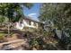 View of a terraced backyard with various shrubs, trees, and a screened in porch extending along the back of the house at 1224 Shorecrest Cir, Clermont, FL 34711