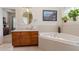 Well-lit bathroom featuring a soaking tub, decorative tile, and a vanity with generous counter space at 1224 Shorecrest Cir, Clermont, FL 34711